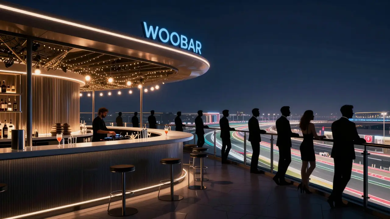 Rooftop bar at W Abu Dhabi with city lights and the illuminated Yas Marina Circuit below.