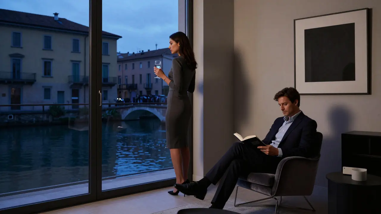 A man and woman in a private Milan apartment, one reading, the other looking out at the canal at dusk.