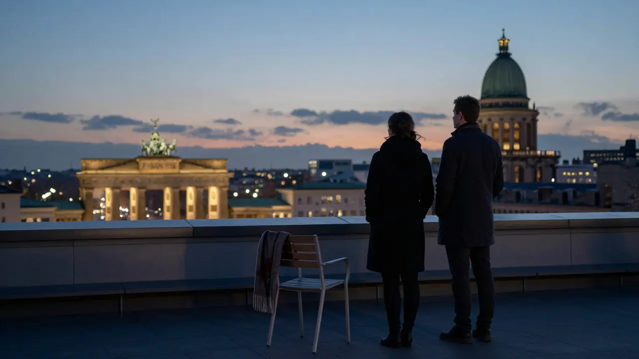 Two people standing silently on a rooftop terrace overlooking Berlin's city lights at twilight.